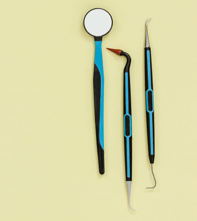 Professional oral care kit tools laid out on a light yellow background