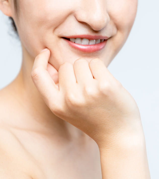 Close up photo of young woman with her hand at her jaw