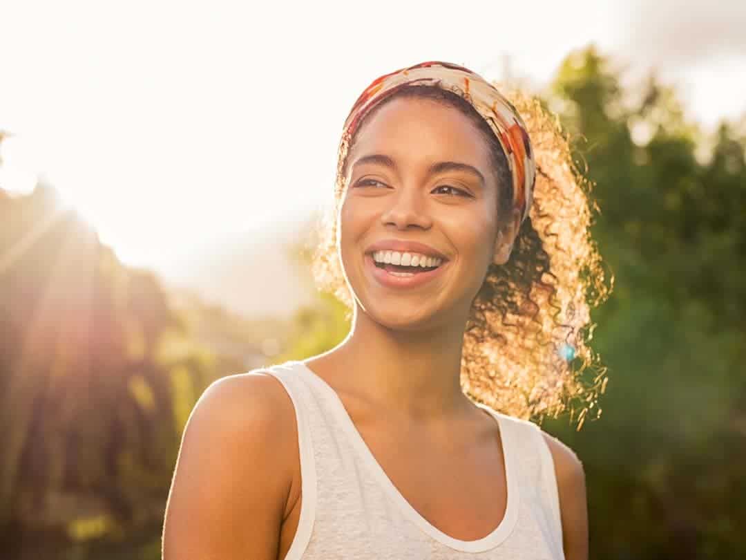 Young woman smiling in the sunset