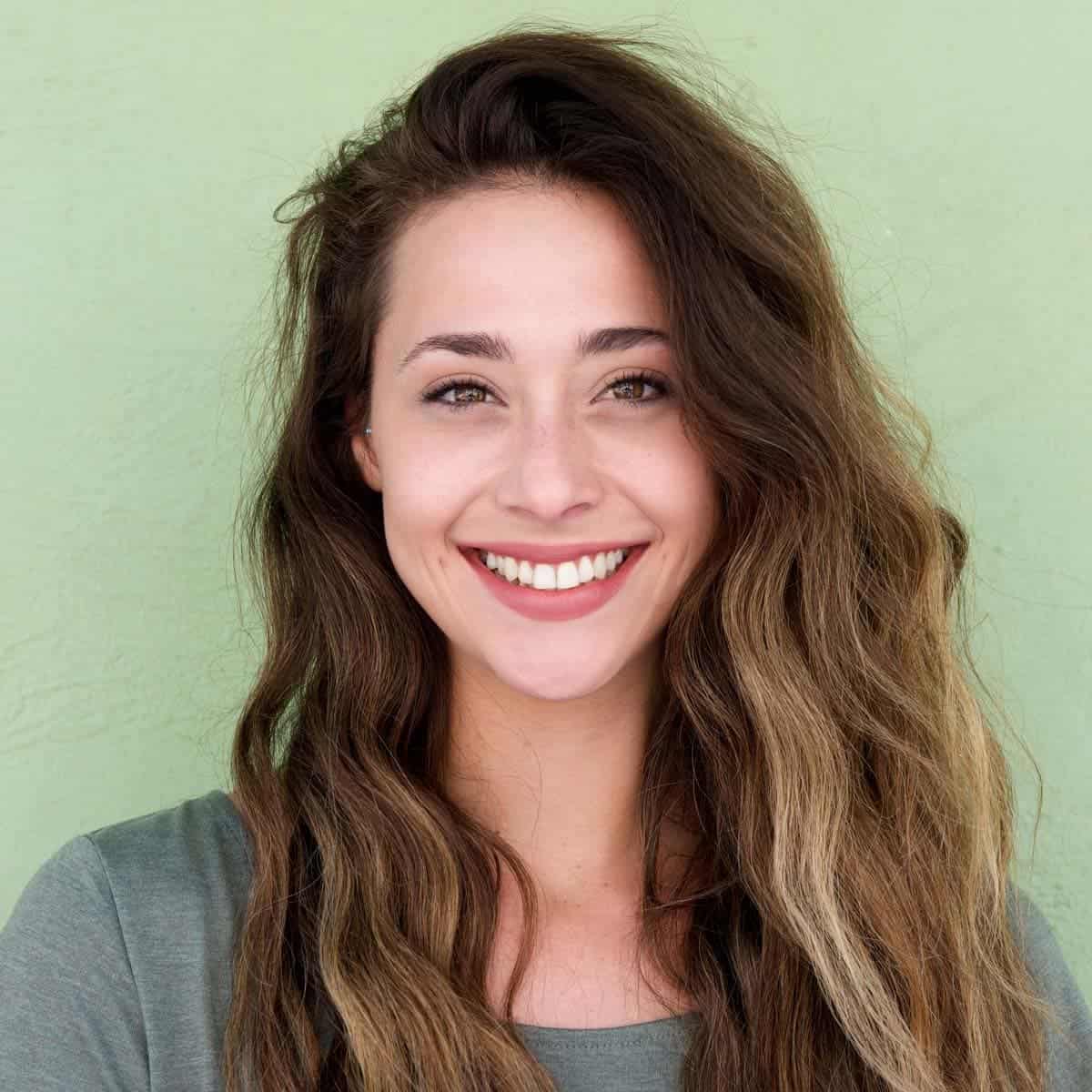 Portrait of a young woman smiling with a green background