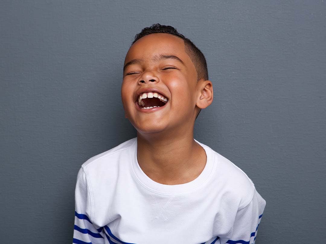 Young child laughing with head tilted